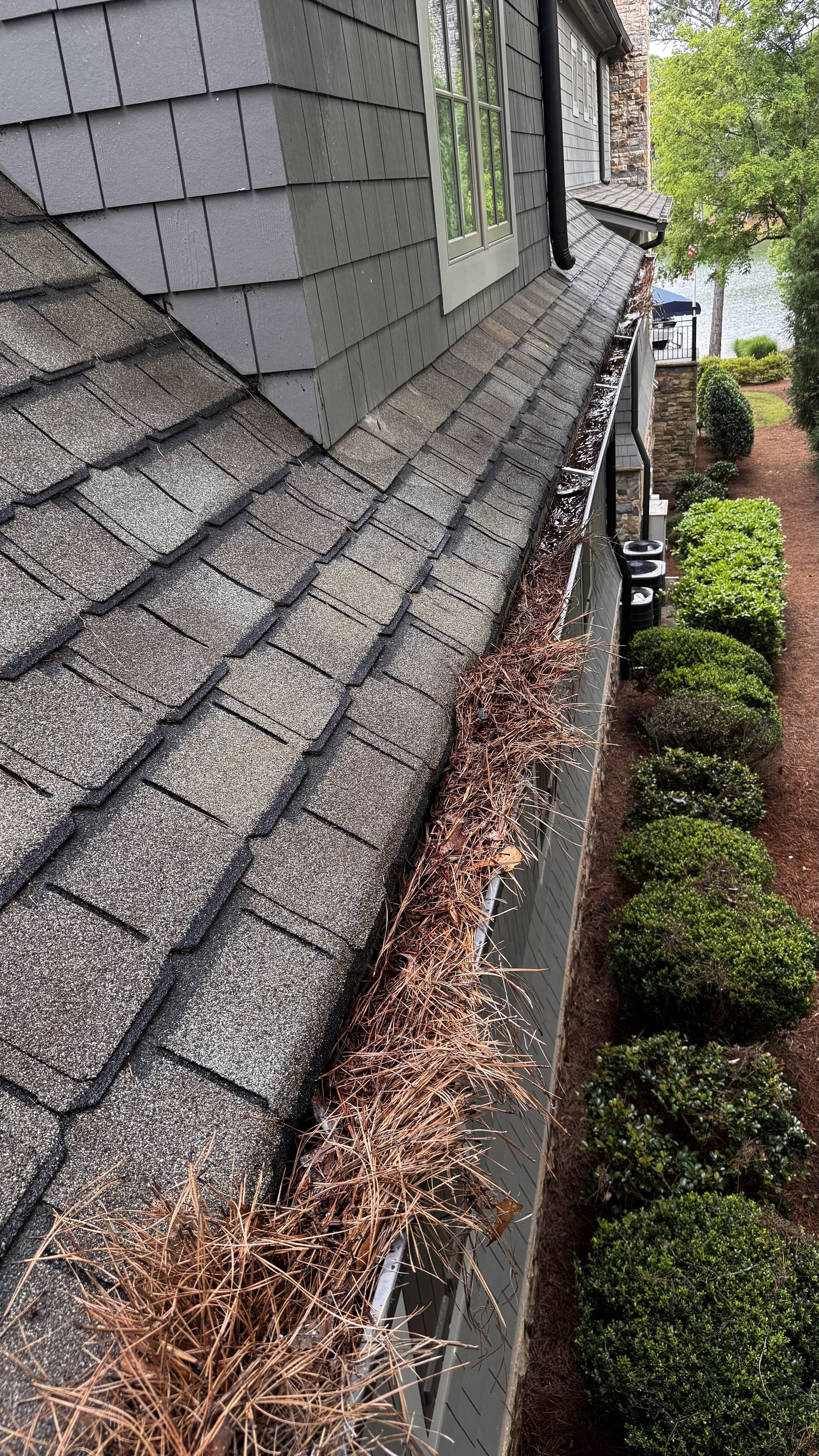 Clogged gutters full of debris before cleaning Lake Oconee GA